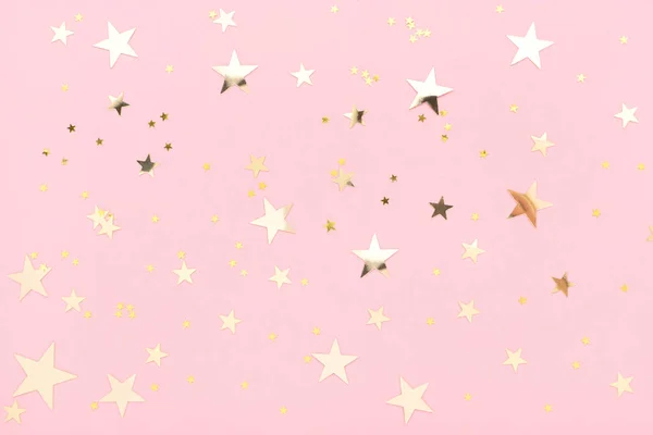 Pembe pastel renkli arka plan, yıldız şeklinde parlayan altın konfetisi..