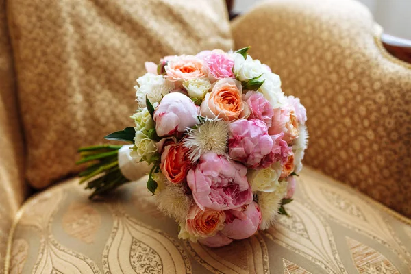 Wedding bridal bouquet with roses and other flowers on arm chair