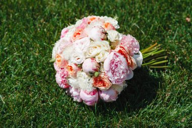Peonies ve gül tam Bloom yeşil çim yakın çekim yalan oluşan muhteşem çiçek çiçek güzel buket. Düğün günü. Gelin aksesuarları