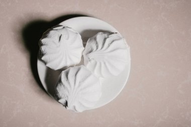 Bir uçan daire yakın çekim üzerinde üç lezzetli tatlı tatlı beyaz Marshmallow zephyr. Kopya alanı