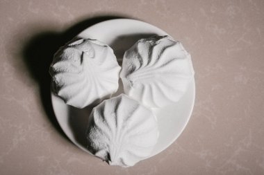 Bir uçan daire yakın çekim üzerinde üç lezzetli tatlı tatlı beyaz Marshmallow zephyr. Kopya alanı