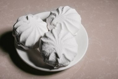 Bir uçan daire yakın çekim üzerinde üç lezzetli tatlı tatlı beyaz Marshmallow zephyr. Kopya alanı