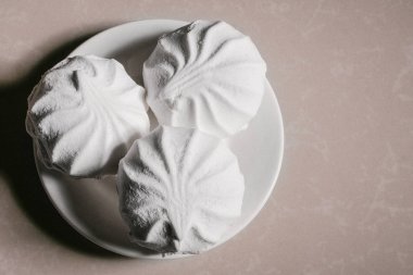 Bir uçan daire yakın çekim üzerinde üç lezzetli tatlı tatlı beyaz Marshmallow zephyr. Kopya alanı