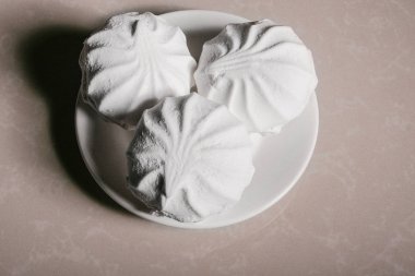 Bir uçan daire yakın çekim üzerinde üç lezzetli tatlı tatlı beyaz Marshmallow zephyr. Kopya alanı