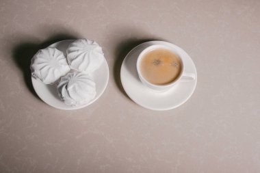 Bir fincan taze kahve, americano ve bir uçan daire portre üzerinde üç lezzetli tatlı tatlı beyaz Marshmallow. Kopya alanı