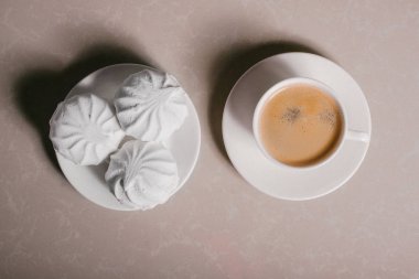 Bir fincan taze kahve, americano ve bir uçan daire portre üzerinde üç lezzetli tatlı tatlı beyaz Marshmallow. Kopya alanı