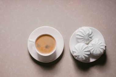 Bir fincan taze kahve, americano ve bir uçan daire portre üzerinde üç lezzetli tatlı tatlı beyaz Marshmallow. Kopya alanı