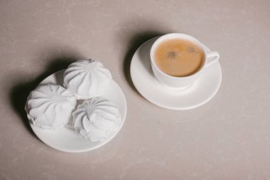 Bir fincan taze kahve, americano ve bir uçan daire portre üzerinde üç lezzetli tatlı tatlı beyaz Marshmallow. Kopya alanı