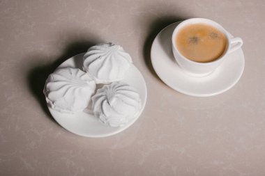 Bir fincan taze kahve, americano ve bir uçan daire portre üzerinde üç lezzetli tatlı tatlı beyaz Marshmallow. Kopya alanı