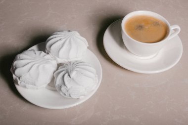 Bir fincan taze kahve, americano ve bir uçan daire portre üzerinde üç lezzetli tatlı tatlı beyaz Marshmallow. Kopya alanı