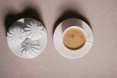 Bir fincan taze kahve, americano ve bir uçan daire portre üzerinde üç lezzetli tatlı tatlı beyaz Marshmallow. Kopya alanı