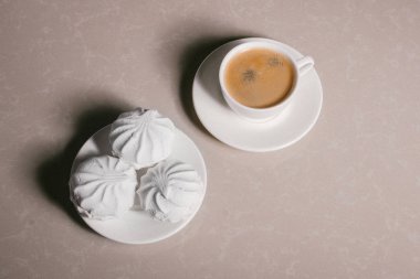 Bir fincan taze kahve, americano ve bir uçan daire portre üzerinde üç lezzetli tatlı tatlı beyaz Marshmallow. Kopya alanı