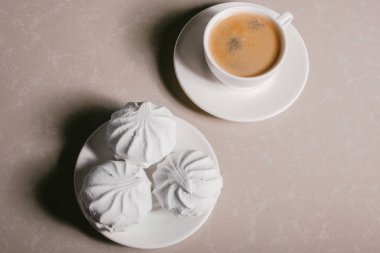 Bir fincan taze kahve, americano ve bir uçan daire portre üzerinde üç lezzetli tatlı tatlı beyaz Marshmallow. Kopya alanı