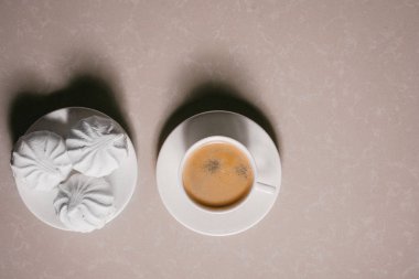 Bir fincan taze kahve, americano ve bir uçan daire portre üzerinde üç lezzetli tatlı tatlı beyaz Marshmallow. Kopya alanı