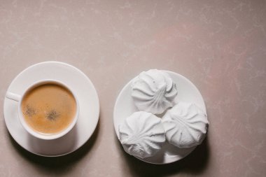 Bir fincan taze kahve, americano ve bir uçan daire portre üzerinde üç lezzetli tatlı tatlı beyaz Marshmallow. Kopya alanı