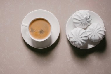 Bir fincan taze kahve, americano ve bir uçan daire portre üzerinde üç lezzetli tatlı tatlı beyaz Marshmallow. Kopya alanı