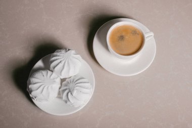 Bir fincan taze kahve, americano ve bir uçan daire portre üzerinde üç lezzetli tatlı tatlı beyaz Marshmallow. Kopya alanı