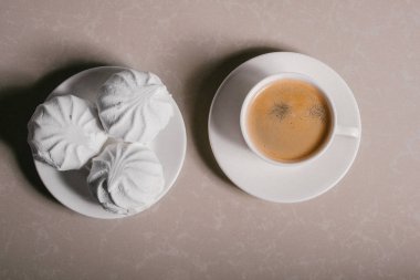 Bir fincan taze kahve, americano ve bir uçan daire portre üzerinde üç lezzetli tatlı tatlı beyaz Marshmallow. Kopya alanı