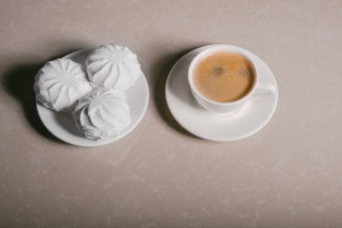 Bir fincan taze kahve, americano ve bir uçan daire portre üzerinde üç lezzetli tatlı tatlı beyaz Marshmallow. Kopya alanı