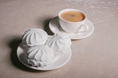 Bir fincan taze kahve, americano ve bir uçan daire portre üzerinde üç lezzetli tatlı tatlı beyaz Marshmallow. Kopya alanı