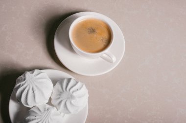 Bir fincan taze kahve, americano ve bir uçan daire portre üzerinde üç lezzetli tatlı tatlı beyaz Marshmallow. Kopya alanı