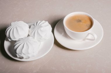 Bir fincan taze kahve, americano ve bir uçan daire portre üzerinde üç lezzetli tatlı tatlı beyaz Marshmallow. Kopya alanı