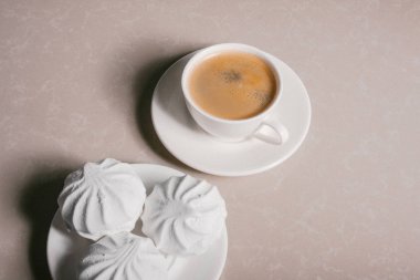 Bir fincan taze kahve, americano ve bir uçan daire portre üzerinde üç lezzetli tatlı tatlı beyaz Marshmallow. Kopya alanı