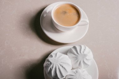 Bir fincan taze kahve, americano ve bir uçan daire portre üzerinde üç lezzetli tatlı tatlı beyaz Marshmallow. Kopya alanı