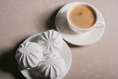 Bir fincan taze kahve, americano ve bir uçan daire portre üzerinde üç lezzetli tatlı tatlı beyaz Marshmallow. Kopya alanı