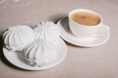 Bir fincan taze kahve, americano ve bir uçan daire portre üzerinde üç lezzetli tatlı tatlı beyaz Marshmallow. Kopya alanı