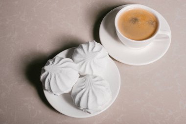 Bir fincan taze kahve, americano ve bir uçan daire portre üzerinde üç lezzetli tatlı tatlı beyaz Marshmallow. Kopya alanı