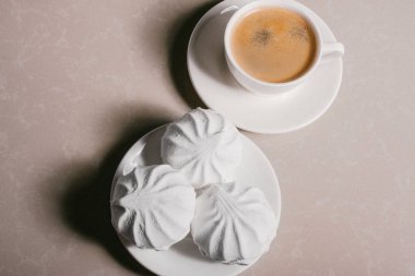 Bir fincan taze kahve, americano ve bir uçan daire portre üzerinde üç lezzetli tatlı tatlı beyaz Marshmallow. Kopya alanı