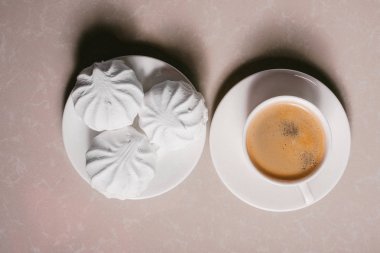 Bir fincan taze kahve, americano ve bir uçan daire portre üzerinde üç lezzetli tatlı tatlı beyaz Marshmallow. Kopya alanı