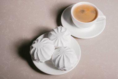 Bir fincan taze kahve, americano ve bir uçan daire portre üzerinde üç lezzetli tatlı tatlı beyaz Marshmallow. Kopya alanı