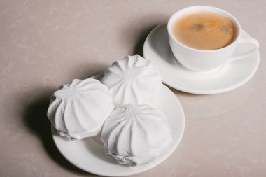 Bir fincan taze kahve, americano ve bir uçan daire portre üzerinde üç lezzetli tatlı tatlı beyaz Marshmallow. Kopya alanı