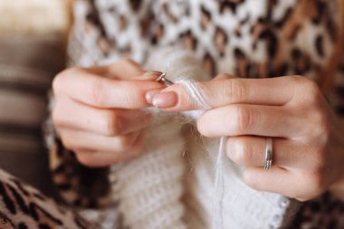 Kadın örgü yün elbise eller. Örgü iğneleri. Yakın çekim. Doğal yün. Yatay fotoğraf. Serbest yaratıcı çalışma ve yaşam kavramı