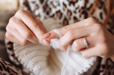 Kadın örgü yün elbise eller. Örgü iğneleri. Yakın çekim. Doğal yün. Yatay fotoğraf. Serbest yaratıcı çalışma ve yaşam kavramı