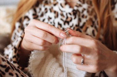 Kadın örgü yün elbise eller. Örgü iğneleri. Yakın çekim. Doğal yün. Yatay fotoğraf. Serbest yaratıcı çalışma ve yaşam kavramı