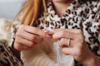 Kadın örgü yün elbise eller. Örgü iğneleri. Yakın çekim. Doğal yün. Yatay fotoğraf. Serbest yaratıcı çalışma ve yaşam kavramı