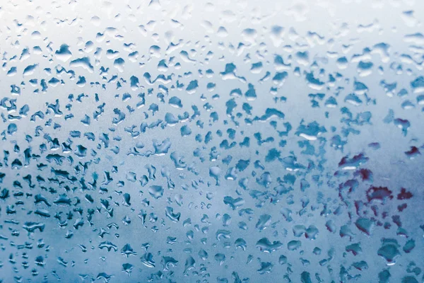 Strong humidity in wintertime. Water drops from home condensation on a window. Misted glass background