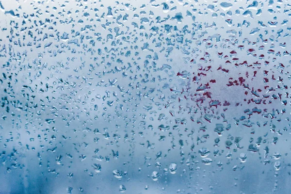 Strong humidity in wintertime. Water drops from home condensation on a window. Misted glass background