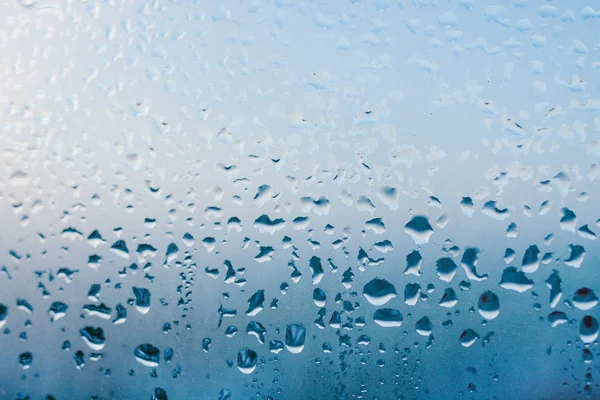 Strong humidity in wintertime. Water drops from home condensation on a window. Misted glass background