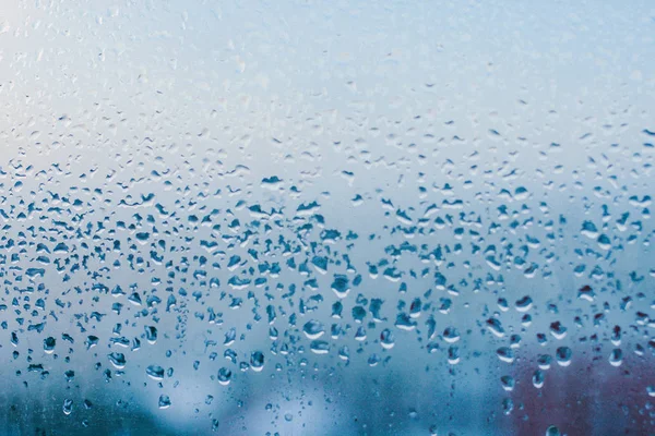 Strong humidity in wintertime. Water drops from home condensation on a window. Misted glass background