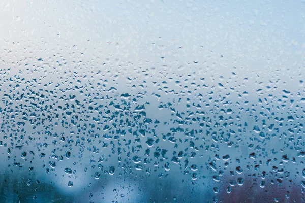 Strong humidity in wintertime. Water drops from home condensation on a window. Misted glass background