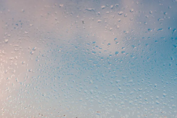 Strong humidity in wintertime. Water drops from home condensation on a window. Misted glass background