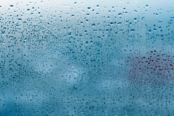Misted glass background. Strong humidity in wintertime. Water drops from home condensation on a window