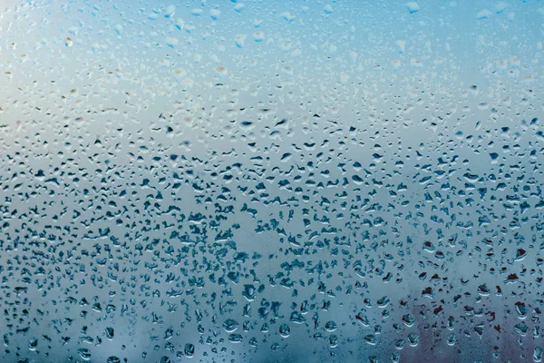 Misted glass background. Strong humidity in wintertime. Water drops from home condensation on a window