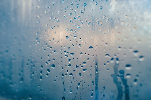 Strong humidity in wintertime. Water drops from home condensation on a window. Misted glass background