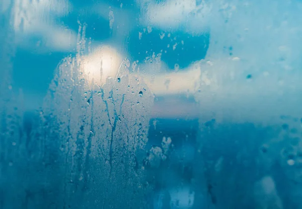 Water drops from home condensation on a window. Misted glass background. Strong humidity in wintertime