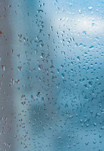 Water drops from home condensation on a window. Misted glass background. Strong humidity in wintertime